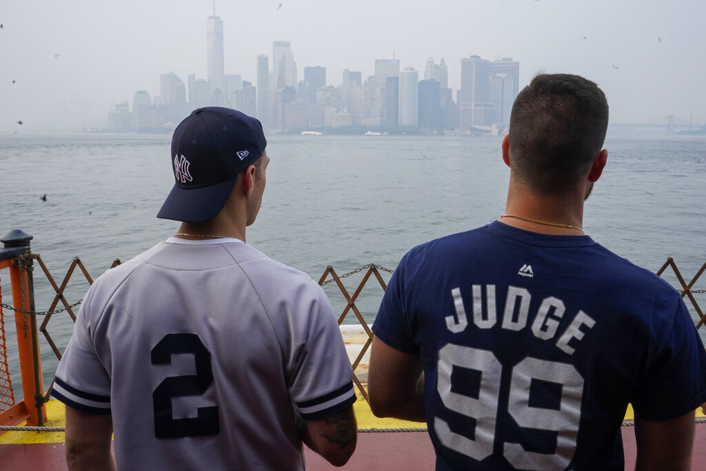 Staten Island Ferry commuters take in the view of lower Manhattan through the haze on Tuesday. Smoke from wildfires across the U.S. West, including Oregon's Bootleg Fire, has wafted over large swaths of the eastern United States. David Lawrence, a meteorologist with the National Weather Service, said the skies could be hazy for the next couple weeks. (AP Photo/Mary Altaffer)