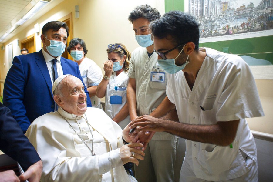 Pope Francis is greeted by hospital staff as he sits in a wheelchair inside the Agostino Gemelli Polyclinic in Rome, Sunday, July 11, 2021, where he was hospitalized for intestine surgery. (Vatican Media via AP)