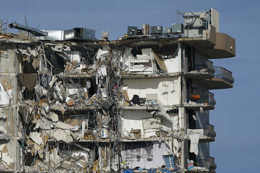 Furniture and household items are perched in the remains of destroyed apartments, in the still standing section of the Champlain Towers South condo building on Thursday, July 1, 2021, in Surfside, Fla. Scores of people remain missing one week after the building partially collapsed.(AP Photo/Mark Humphrey)