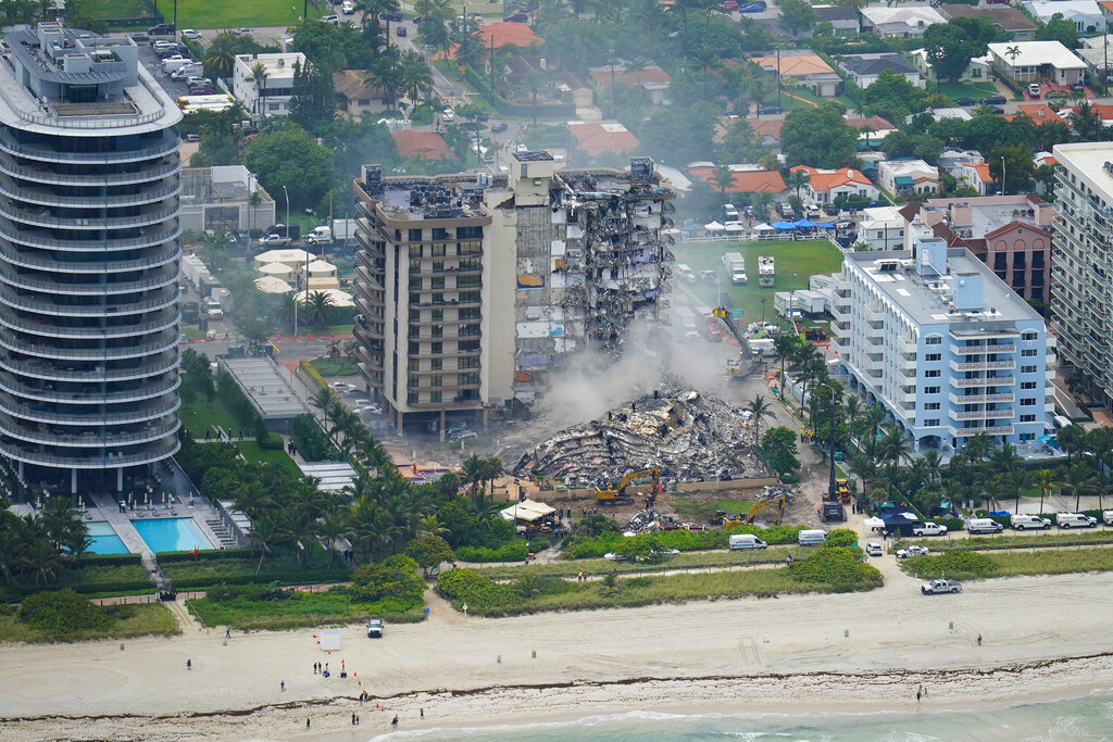 Rescue personnel work in the rubble at the Champlain Towers South Condo, in Surfside, Fla. on Friday. Even as the search continues over a week later for signs of life in the mangled debris of the fallen Champlain Towers South, the process of seeking answers about why it happened and who is to blame is already underway in Florida's legal system. (AP Photo/Gerald Herbert, File)