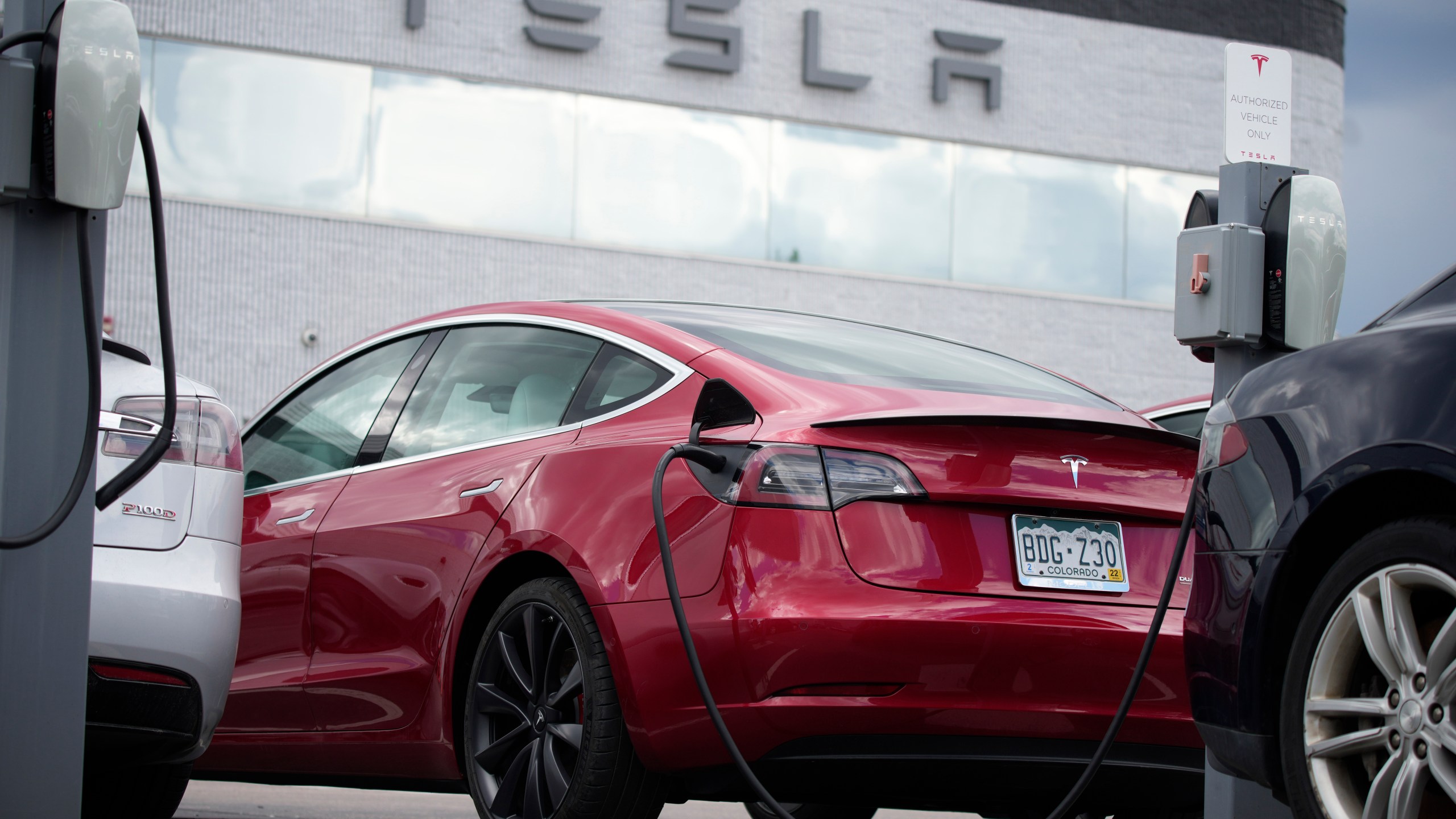 A 2021 Model 3 sedan sits in a near-empty lot at a Tesla dealership in Littleton, Colo. June 27, 2021.