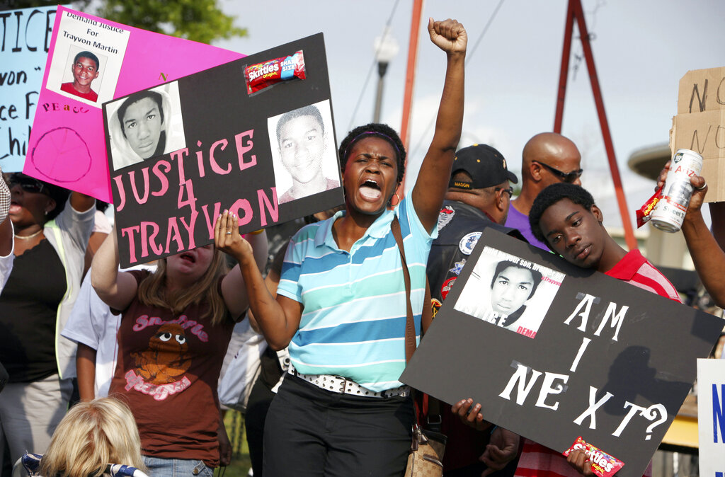 A woman and son stand side by side with protest signs