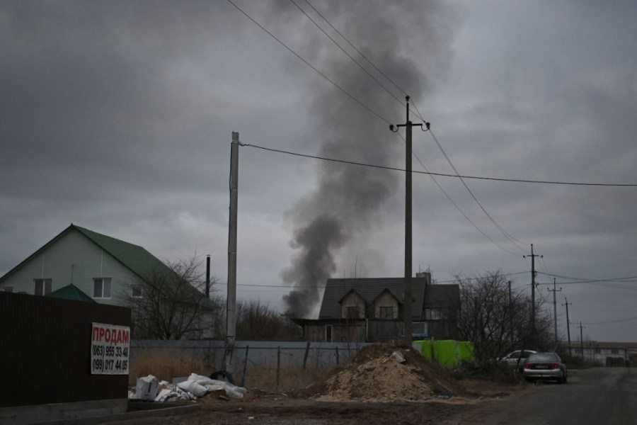 Smoke rises behind some houses