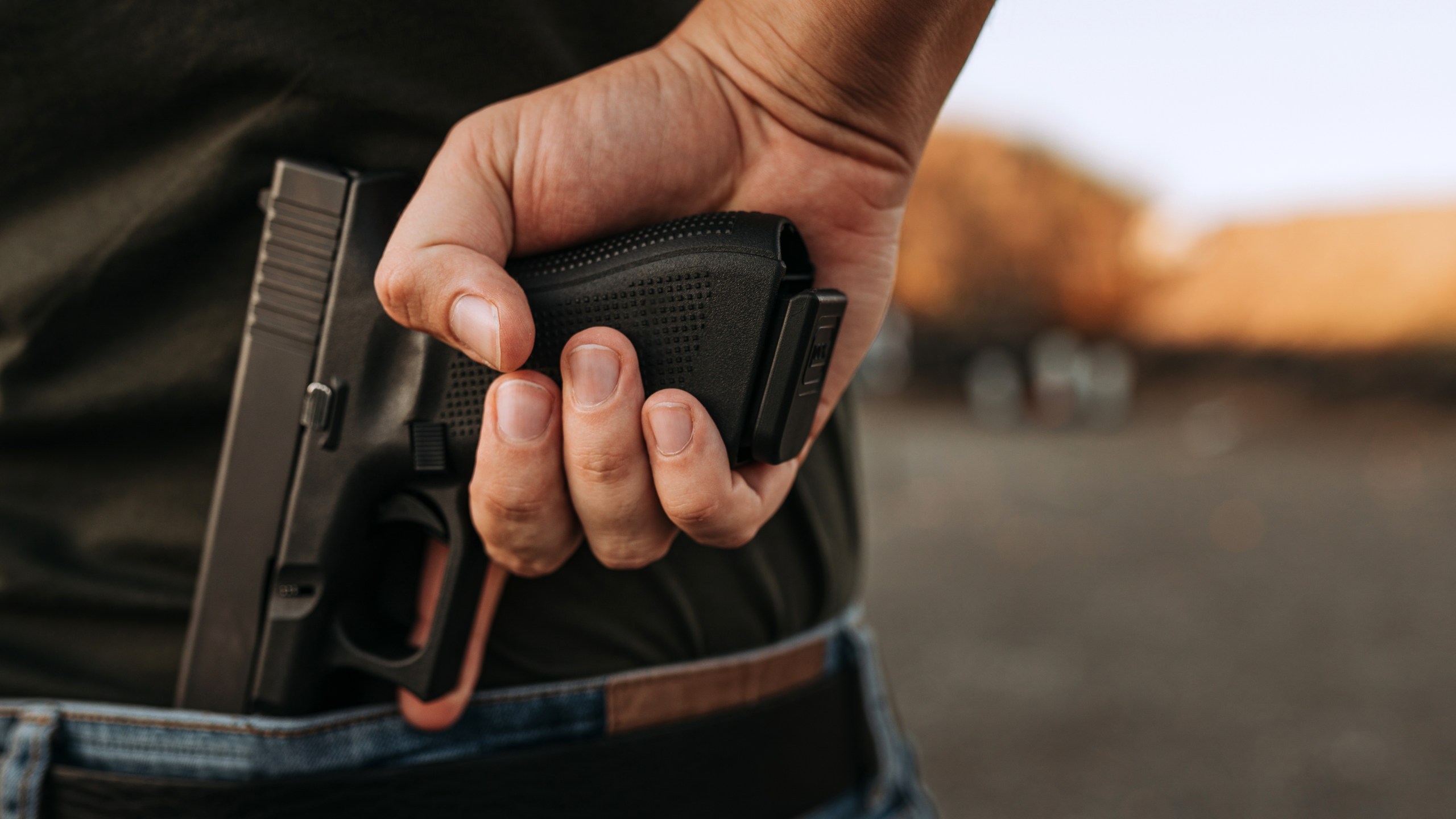 Man holding hidden short gun in his hand