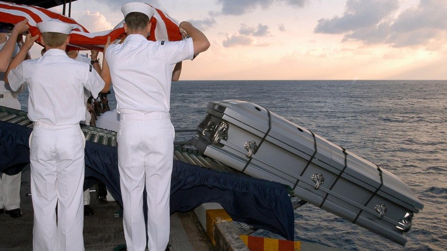 Sailors salute during Burial at Sea ceremony on the USS Enterprise