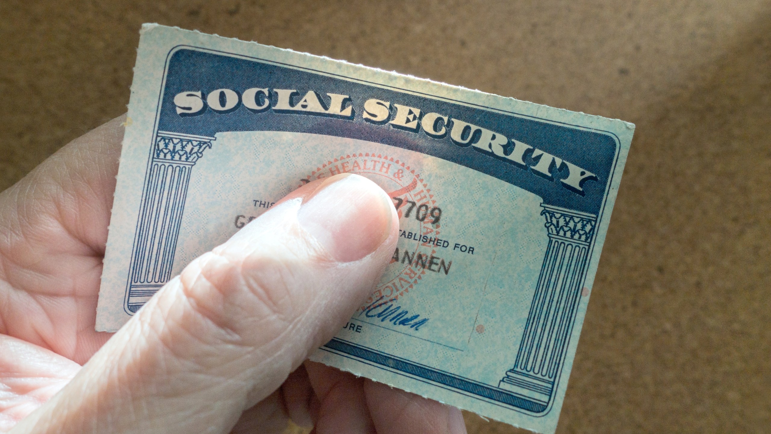 Thumb covering first name of Social Security card