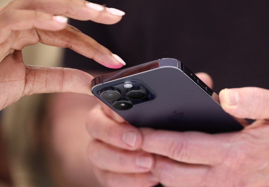 FILE: CUPERTINO, CALIFORNIA - SEPTEMBER 07: Attendees examine a brand new iPhone 14 Pro during an Apple special event on September 07, 2022 in Cupertino, California. Apple CEO Tim Cook unveiled the new iPhone 14 as well as new versions of the Apple Watch, including the Apple Watch SE, a low-cost version of the popular timepiece that will start at $249.