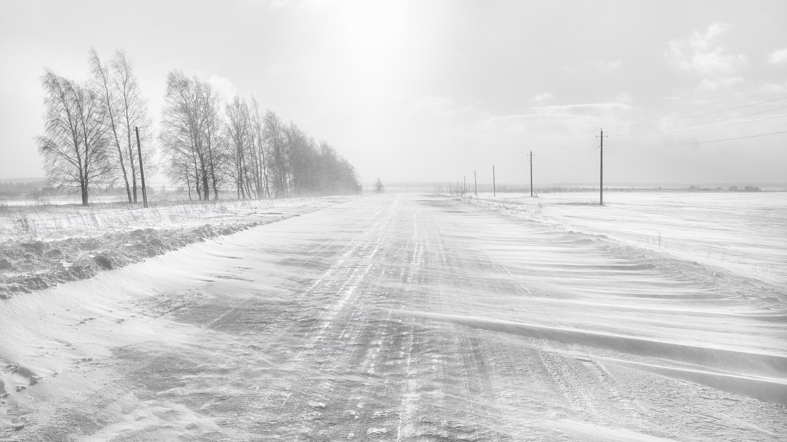 Icy winter road. A blizzard is covering the road with snow.