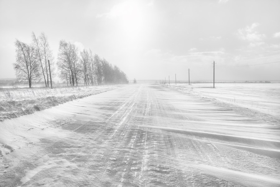 Icy winter road. A blizzard is covering the road with snow.