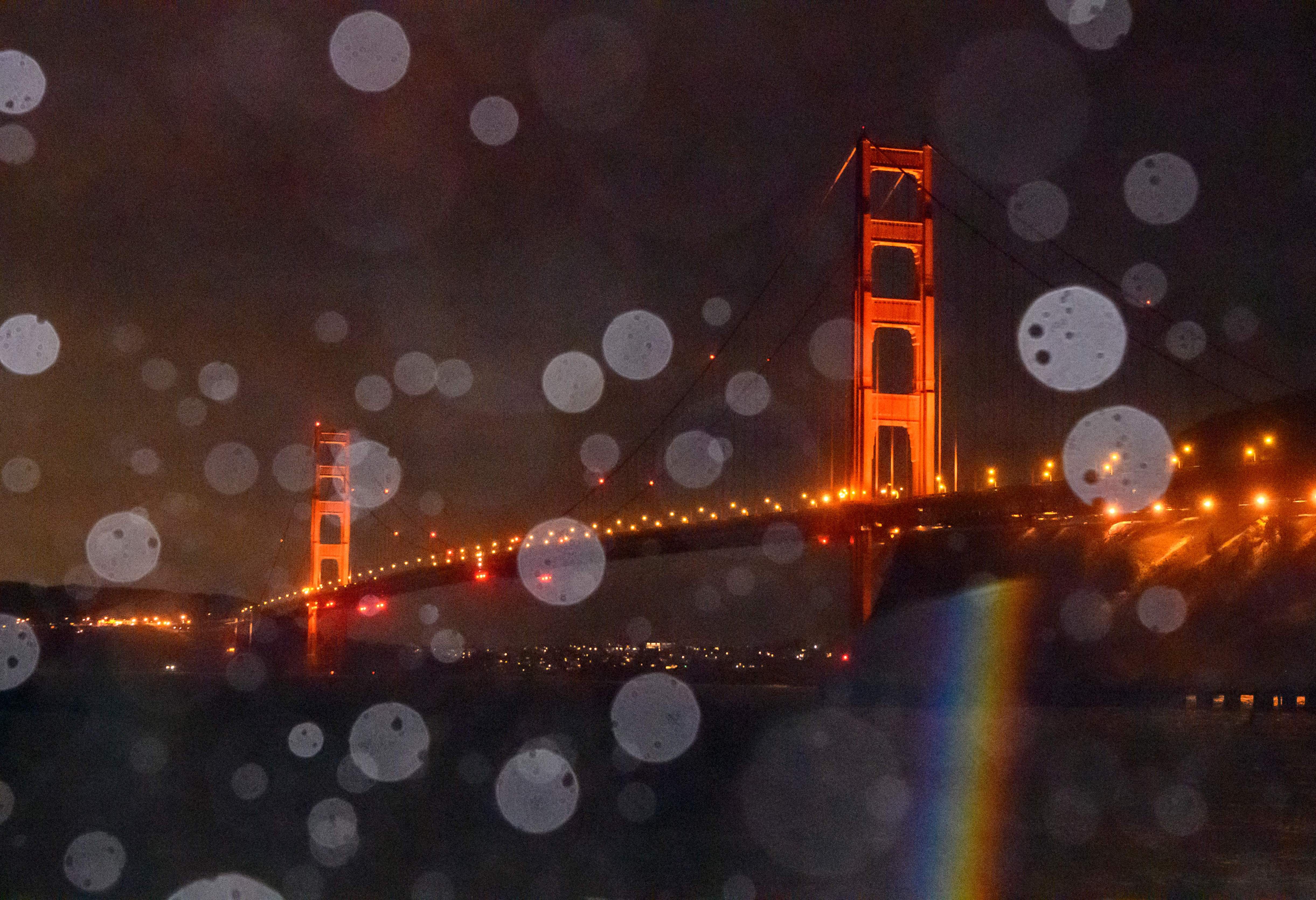 The Golden Gate Bridge is seen through a mix of rain and splashing bay water in Sausalito, California on January 5, 2023. (Photo by JOSH EDELSON / AFP)