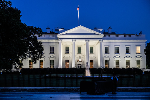 Horizontal color photo of White House in Washington DC on a clear summer evening