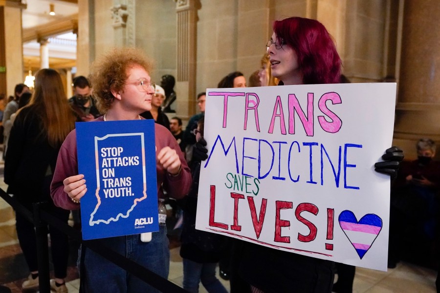 FILE - Protesters stand outside of the Senate chamber at the Indiana Statehouse on Feb. 22, 2023, in Indianapolis. Republican Governors in Indiana and Idaho have signed into law bills banning gender-affirming care for minors early April 2023, making those states the latest to prohibit transgender health care this year. (AP Photo/Darron Cummings, File)