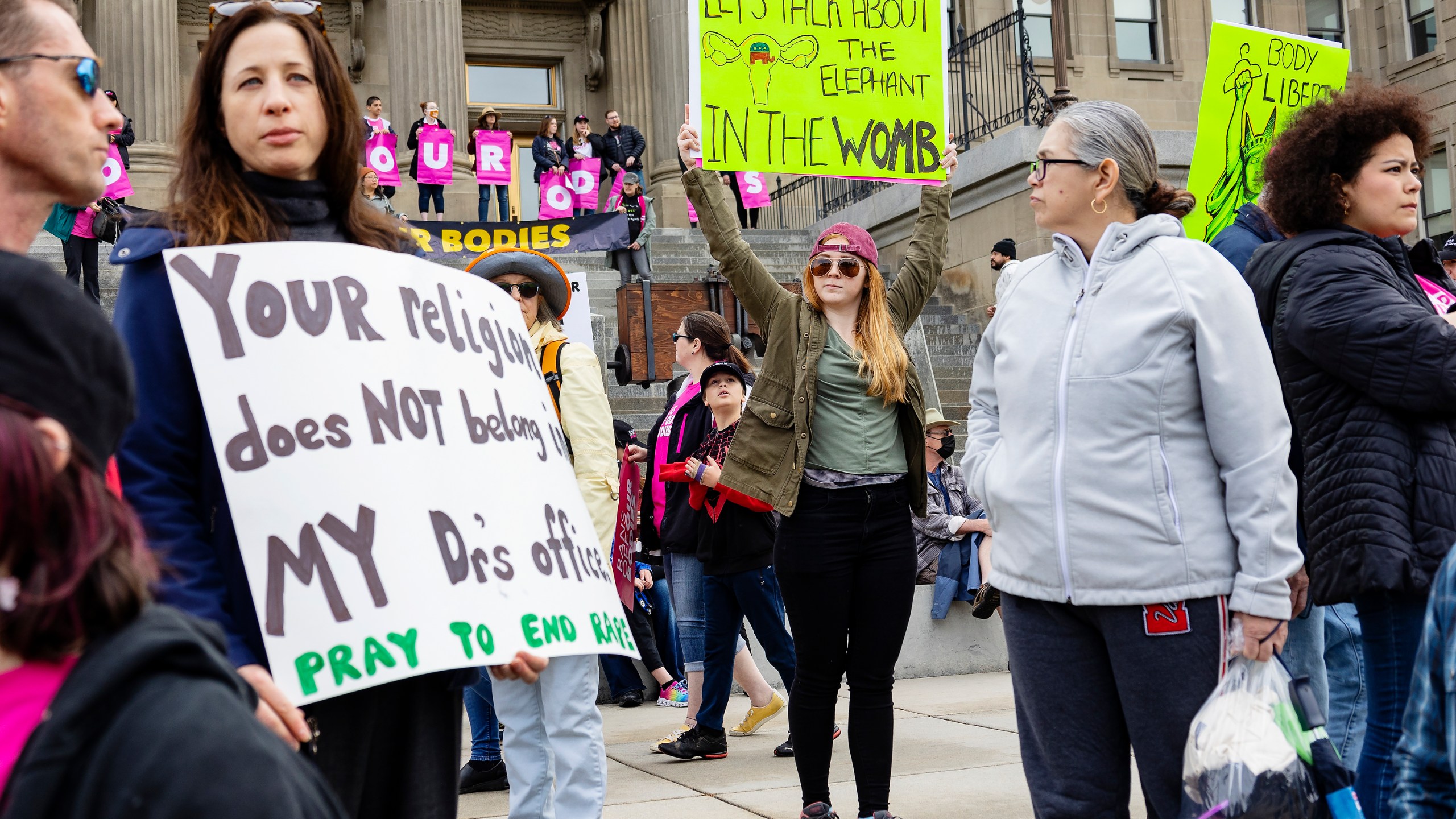 FILE - Boise, Idaho, resident Autumn Myers holds a sign with the Republican Party elephant symbol inside the outline of a uterus that reads, "Let's talk about the elephant in the womb," during a Planned Parenthood rally for abortion rights at the Idaho Statehouse in downtown Boise, May 14, 2022. Idaho lawmakers are considering a measure that would bar adults from taking minors to obtain an abortion without their parent's consent. (Sarah A. Miller/Idaho Statesman via AP, File)