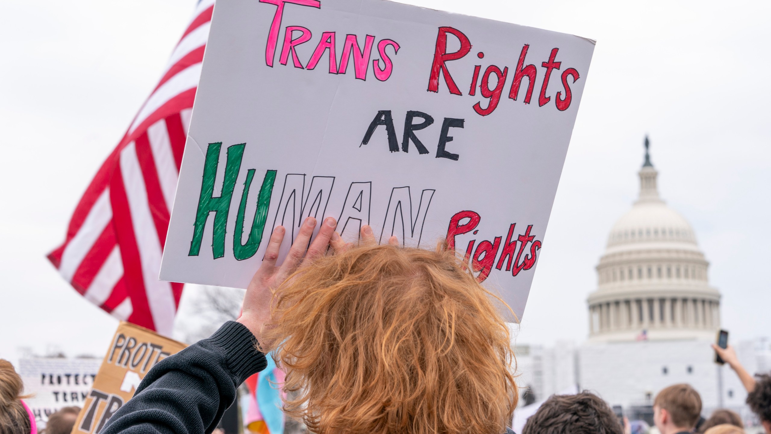 FILE - People attend a rally as part of a Transgender Day of Visibility, Friday, March 31, 2023, by the Capitol in Washington. Schools and colleges across the U.S. would be forbidden from enacting outright bans on transgender athletes under a proposal released Thursday, April 6, from the Biden administration, but teams could create some limits in certain cases, for example, to ensure fairness. (AP Photo/Jacquelyn Martin, File)