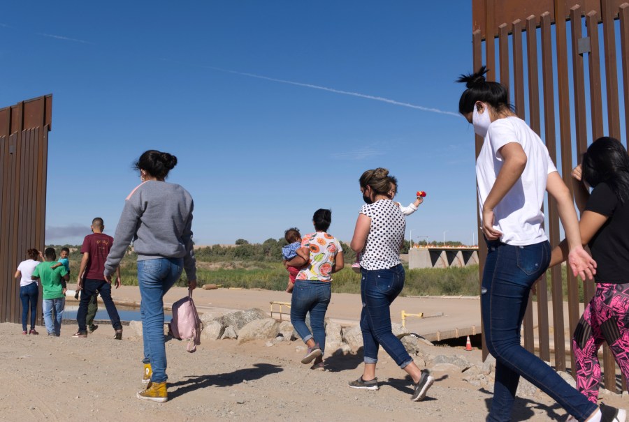 FILE - A group of Brazilian migrants make their way around a gap in the U.S.-Mexico border in Yuma, Ariz., seeking asylum in the U.S. after crossing over from Mexico, June 8, 2021. The U.S. Department of Homeland Security says migrants entering the country illegally will be screened by asylum officers while in custody under a limited experiment that provides them access to legal counsel. (AP Photo/Eugene Garcia, File)