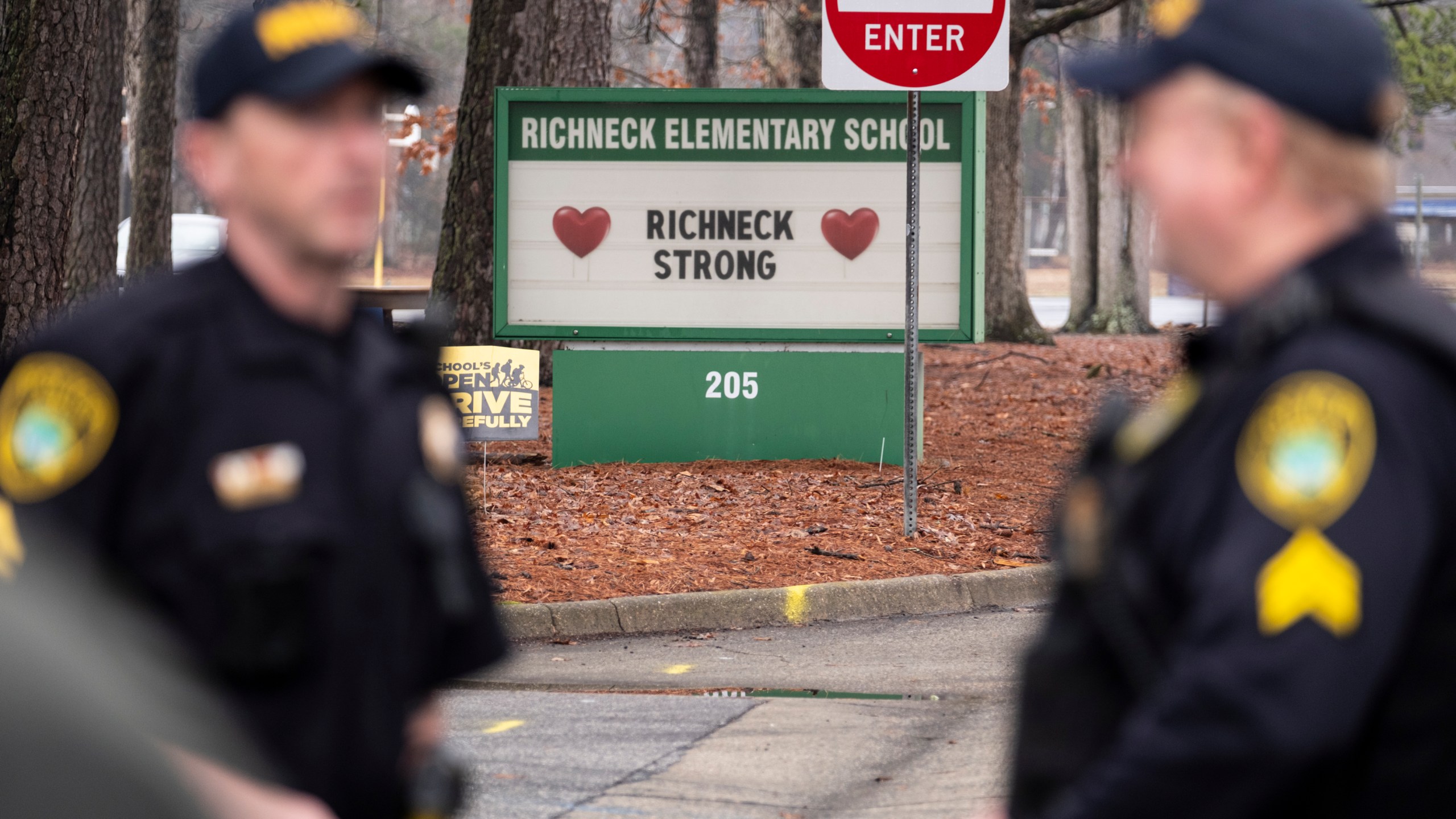 FILE - Police look on as students return to Richneck Elementary on Jan. 30, 2023, in Newport News, Va. A grand jury in Virginia has indicted the mother of a 6-year-old boy who shot his teacher on charges of child neglect and failing to secure her handgun in the family's home, a prosecutor said Monday, April 10. (Billy Schuerman/The Virginian-Pilot via AP, File)