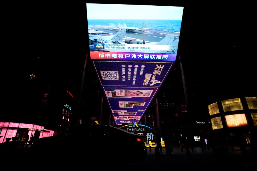 The evening news broadcast shows Chinese fighter jets on an aircraft carrier with the Chinese subtitles "Eastern Battle District successfully concludes the patrol exercise around the taiwan island and Joint Sword exercise" on an outdoor screen in Beijing, Monday, April 10, 2023. China's military declared Monday it is "ready to fight" after completing three days of large-scale combat exercises around Taiwan that simulated sealing off the island in response to the Taiwanese president's trip to the U.S. last week. (AP Photo/Ng Han Guan)