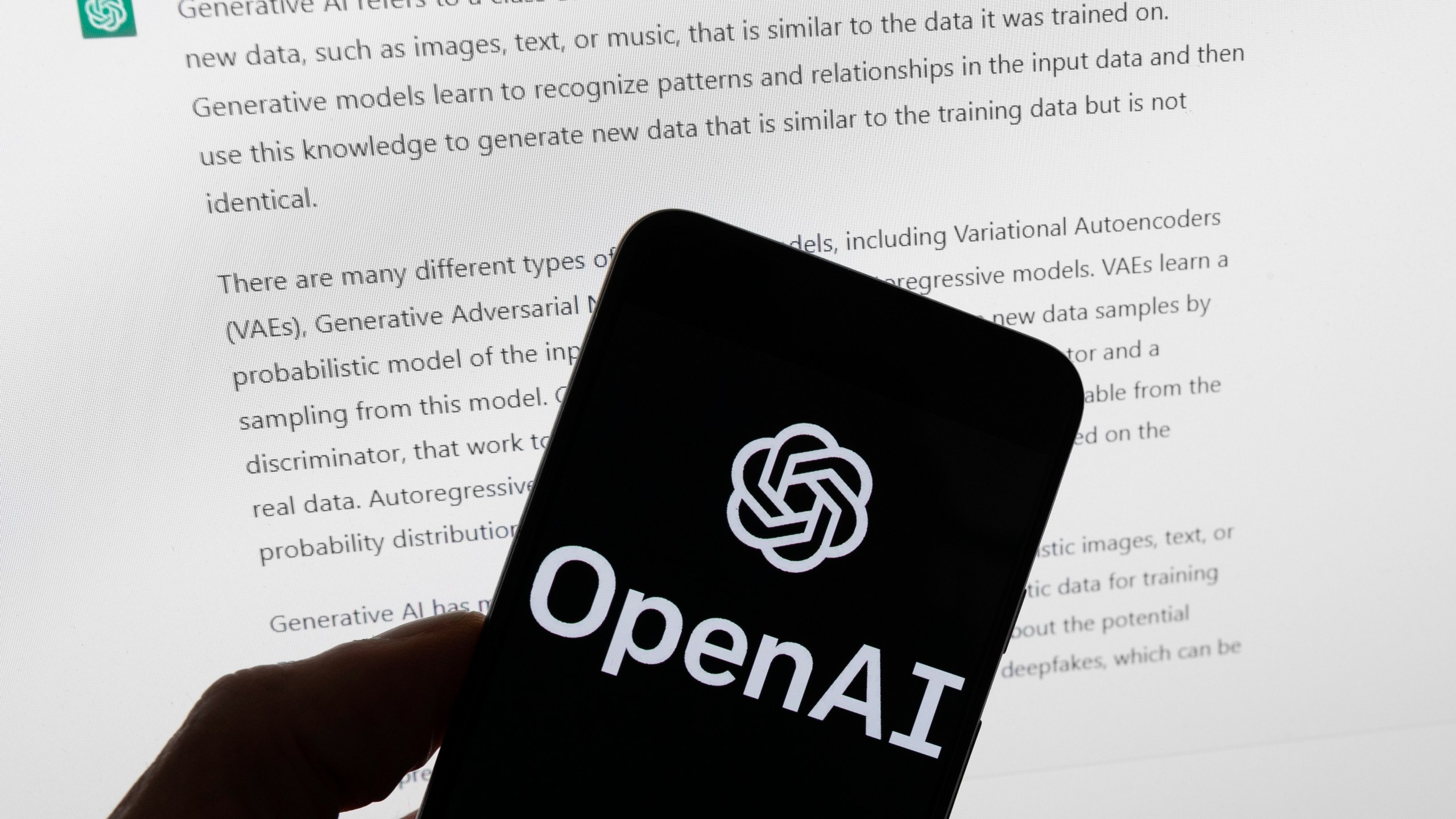 FILE - The OpenAI logo is seen on a mobile phone in front of a computer screen displaying output from ChatGPT, Tuesday, March 21, 2023, in Boston. President Joe Biden’s administration wants stronger measures to test the safety of artificial intelligence tools such as ChatGPT before they are publicly released, though it hasn’t decided if the government will have a role in doing the vetting. The U.S. Commerce Department on Tuesday, April 11, said it will spend the next 60 days fielding opinions on the possibility of AI audits, risk assessments and other measures that could ease consumer concerns about these new systems. (AP Photo/Michael Dwyer, File)