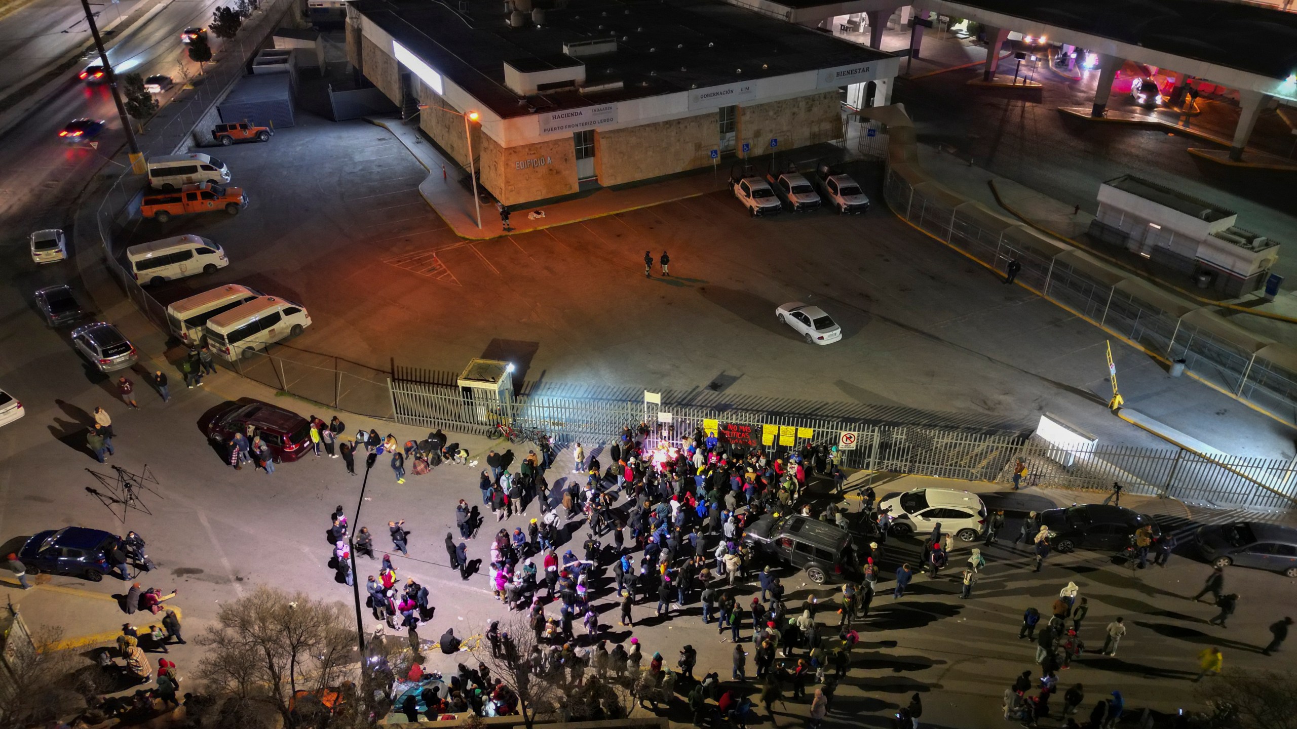 FILE - People take part in a vigil for the victims of a fire at an immigration detention center that killed dozens, outside the detention center in Ciudad Juarez, Mexico, March 28, 2023. Two guards who fled a fire that killed 40 migrants in a locked Mexican detention center did not have keys to the cell door, Mexico’s president said Tuesday, April 11, 2023. (AP Photo/Christian Chavez, File)