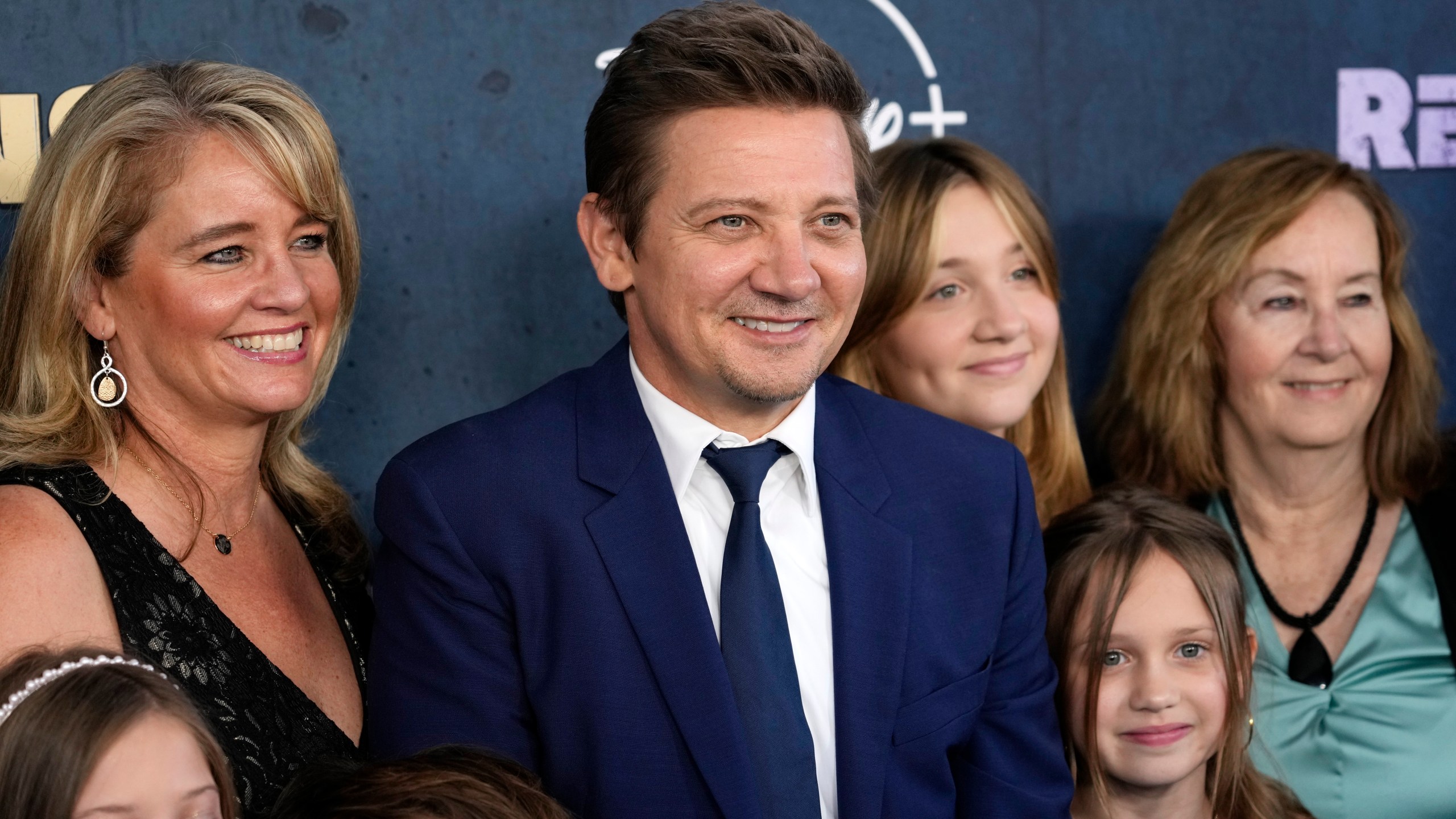 Jeremy Renner, center, the host and executive producer of "Rennervations," is surrounded by family members at the premiere of the four-part Disney+ docuseries, Tuesday, April 11, 2023, at the Westwood Regency Village Theatre in Los Angeles. The premiere marked Renner's first public, in-person appearance since a Jan. 1 snow plow accident outside his Reno, Nev., home left him with life-threatening injuries. (AP Photo/Chris Pizzello)