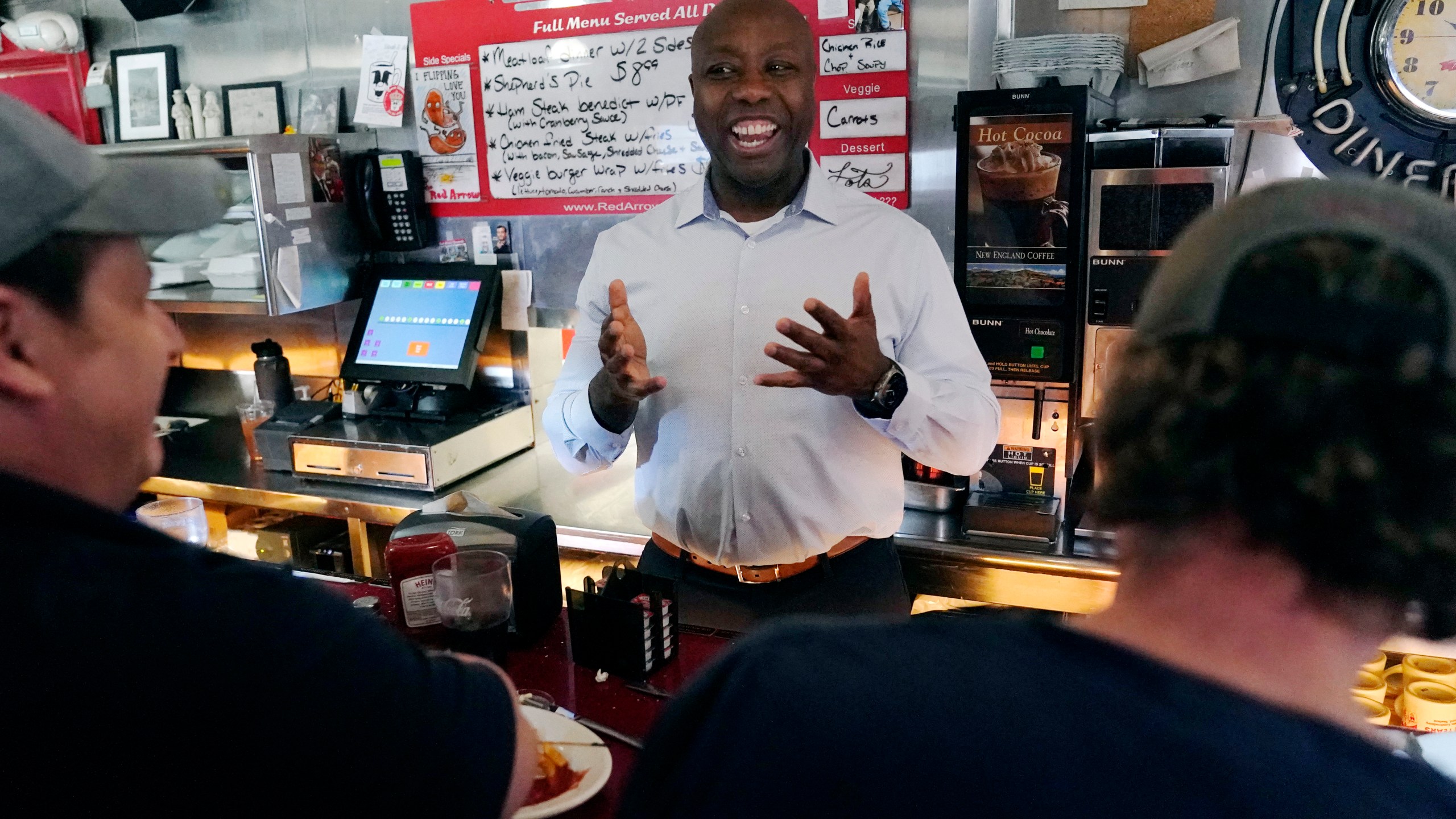 Sen. Tim Scott, R-S.C., talks with diners at the breakfast counter during a visit to the Red Arrow Diner, Thursday, April 13, 2023, in Manchester, N.H. Scott on Wednesday launched an exploratory committee for a 2024 GOP presidential bid, a step that comes just shy of making his campaign official. (AP Photo/Charles Krupa)