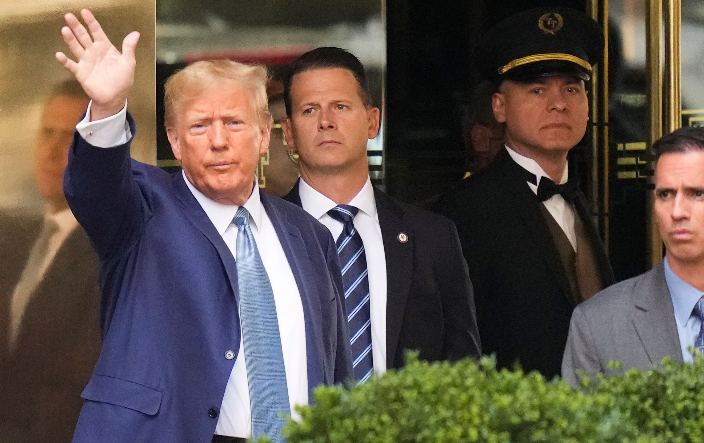 Former President Donald Trump, left, gestures as he leaves Trump Tower in New York, Thursday, April 13, 2023. Trump is expected to visit the offices of New York’s attorney general for his second deposition in a legal battle over his company’s business practices. (AP Photo/Seth Wenig)