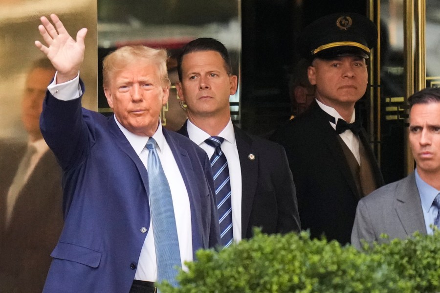 Former President Donald Trump, left, gestures as he leaves Trump Tower in New York, Thursday, April 13, 2023. Trump is expected to visit the offices of New York’s attorney general for his second deposition in a legal battle over his company’s business practices. (AP Photo/Seth Wenig)