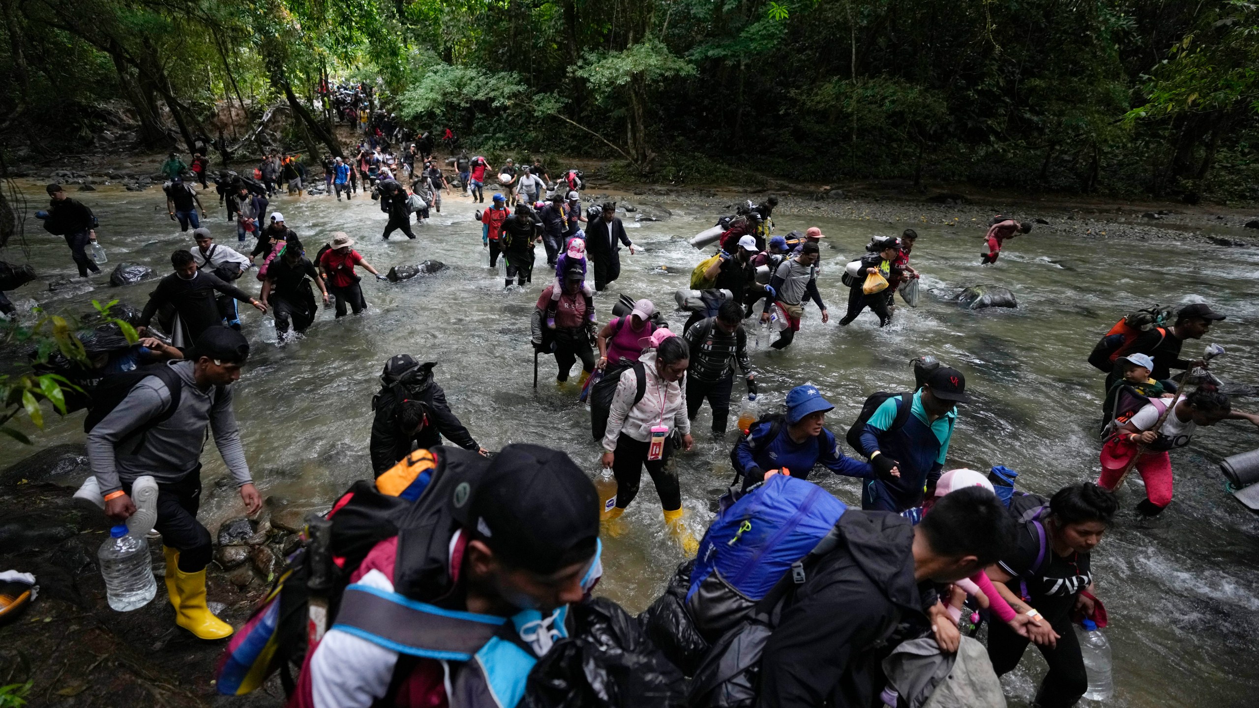 FILE - Migrants, mostly Venezuelans, cross a river during their journey through the Darien Gap from Colombia into Panama, hoping to reach the U.S., Oct. 15, 2022. The United States, Panama and Colombia announced Tuesday, April 11, 2023, that they will launch a 60-day campaign aimed at halting illegal migration through the treacherous Darien Gap, where the flow of migrants has multiplied this year. (AP Photo/Fernando Vergara, File)