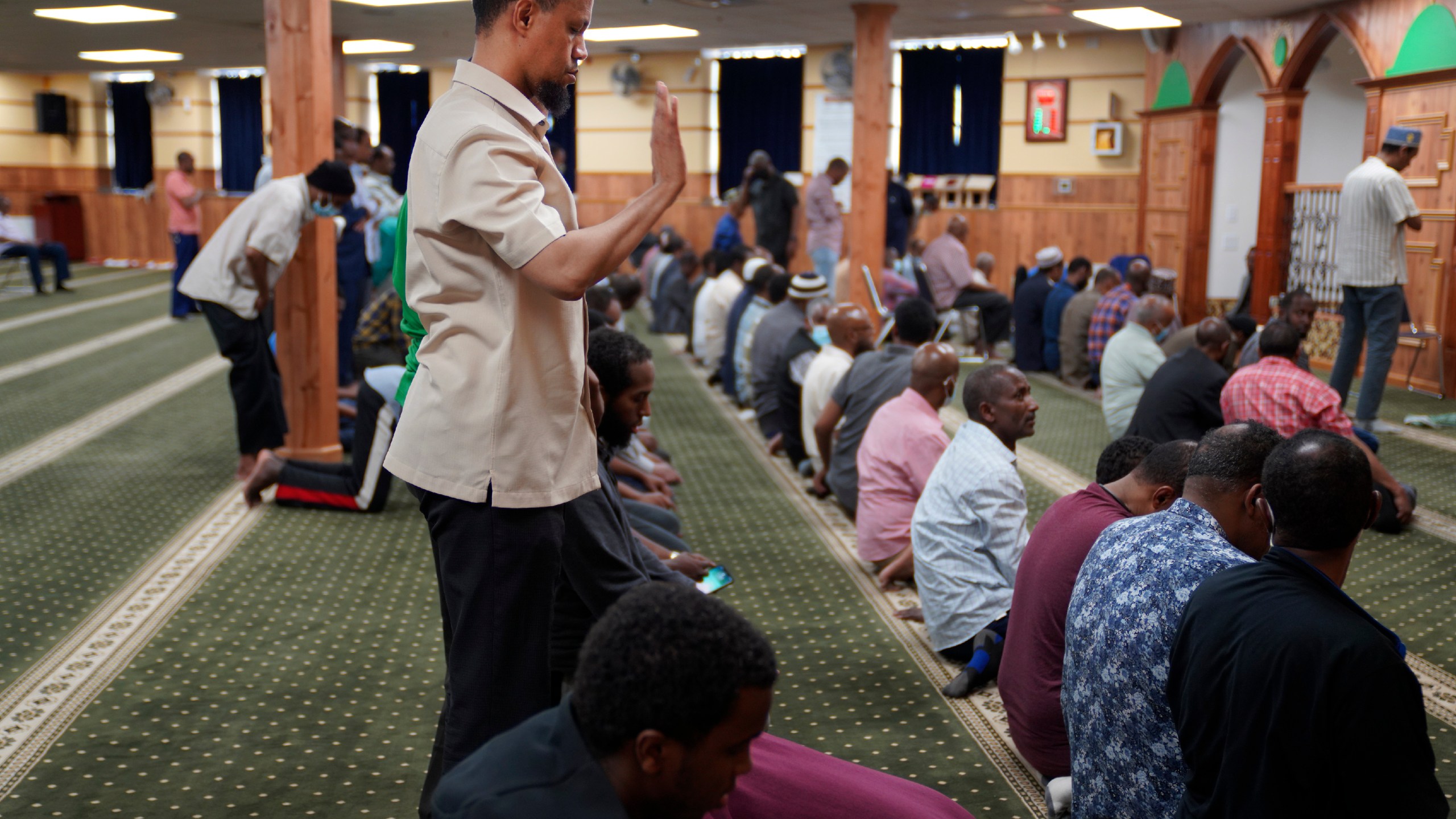 FILE - Yusuf Abdulle, standing, director of the Islamic Association of North America, prays with fellow Muslims at the Abubakar As-Saddique Islamic Center in Minneapolis on Thursday, May 12, 2022. Minneapolis will allow broadcasts of the Muslim call to prayer at all hours, Thursday, April 14, 2023, becoming the first major U.S. city to allow the announcement or “adhan” to be heard over speakers five times a day, year-round. (AP Photo/Jessie Wardarski)