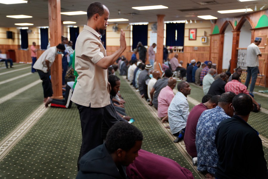 FILE - Yusuf Abdulle, standing, director of the Islamic Association of North America, prays with fellow Muslims at the Abubakar As-Saddique Islamic Center in Minneapolis on Thursday, May 12, 2022. Minneapolis will allow broadcasts of the Muslim call to prayer at all hours, Thursday, April 14, 2023, becoming the first major U.S. city to allow the announcement or “adhan” to be heard over speakers five times a day, year-round. (AP Photo/Jessie Wardarski)