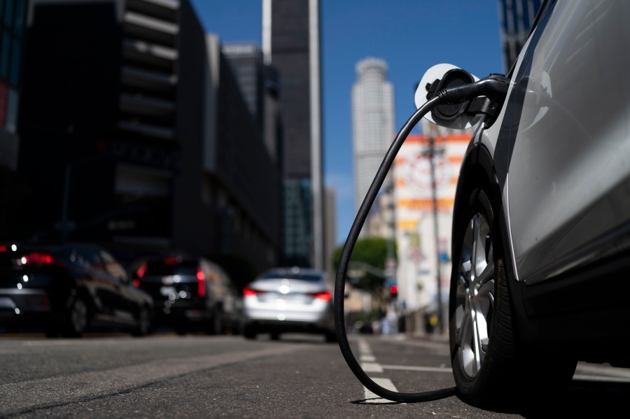 FILE - An electric vehicle is plugged into a charger in Los Angeles, Aug. 25, 2022. Ten electric or plug-in hybrid vehicles will be eligible for a $7,500 U.S. tax credit, while another seven could get $3,750 under new federal rules that go into effect on Tuesday, April 18, 2023. (AP Photo/Jae C. Hong, File)