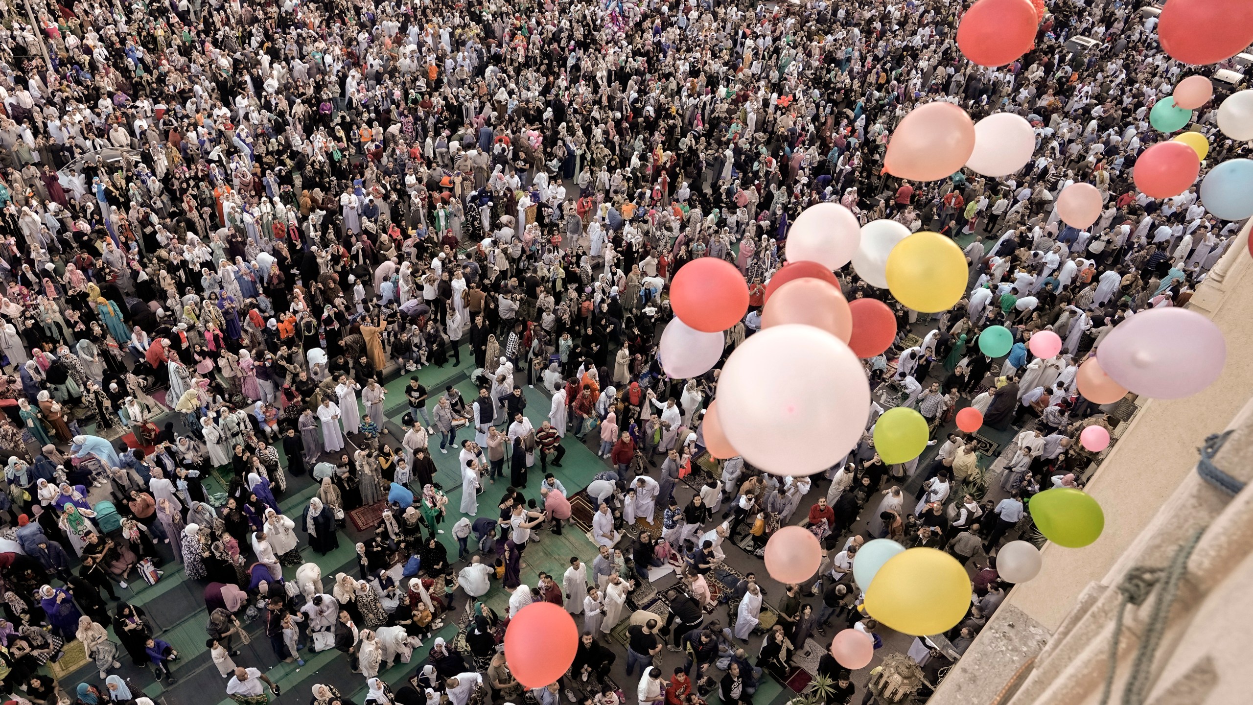 Balloons are distributed for free after Eid al-Fitr prayers, marking the end of the Muslim holy fasting month of Ramadan outside al-Seddik mosque in Cairo, Egypt, Friday, April 21, 2023. (AP Photo/Amr Nabil)