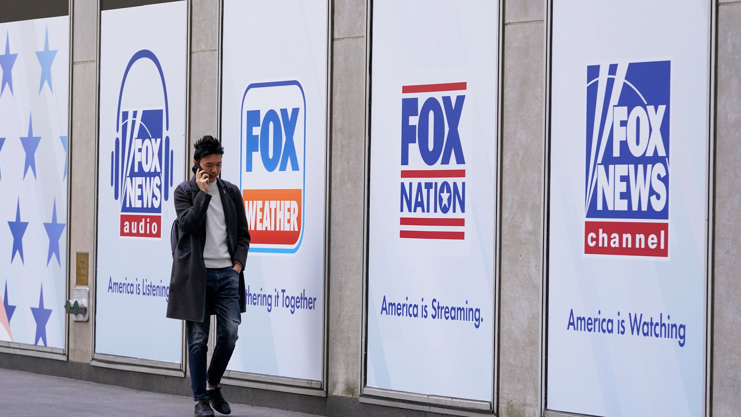 File - A man walks past the News Corp. and Fox News headquarters on Wednesday, April 19, 2023, in New York. Fox Corp.'s hefty $787.5 million settlement with Dominion over defamation charges is unlikely to make a dent in Fox's operations, analysts say. (AP Photo/Mary Altaffer, File)