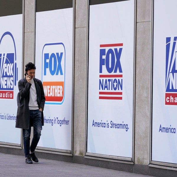 File - A man walks past the News Corp. and Fox News headquarters on Wednesday, April 19, 2023, in New York. Fox Corp.'s hefty $787.5 million settlement with Dominion over defamation charges is unlikely to make a dent in Fox's operations, analysts say. (AP Photo/Mary Altaffer, File)