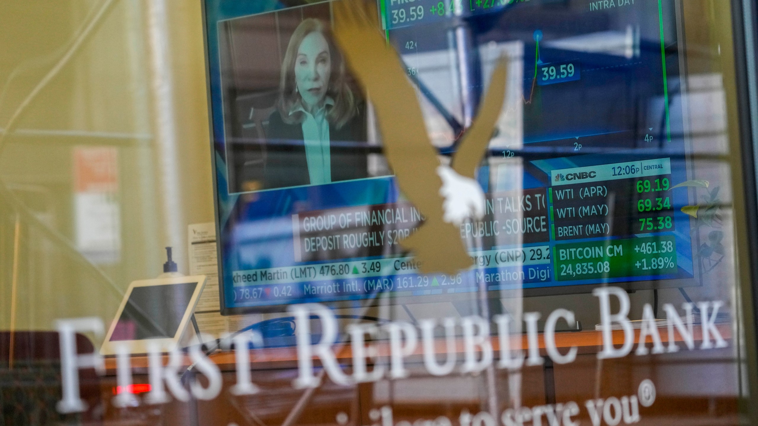 FILE - A television screen displaying financial news, including the stock price of First Republic Bank, is seen inside one of the bank's branches in New York's Financial District, on March 16, 2023. Customers of the bank pulled more than $100 billion in deposits out of the bank during the March crisis, as fears swirled that it could be the third bank to fail after the collapse of Silicon Valley Bank and Signature Bank. (AP Photo/Mary Altaffer, File)