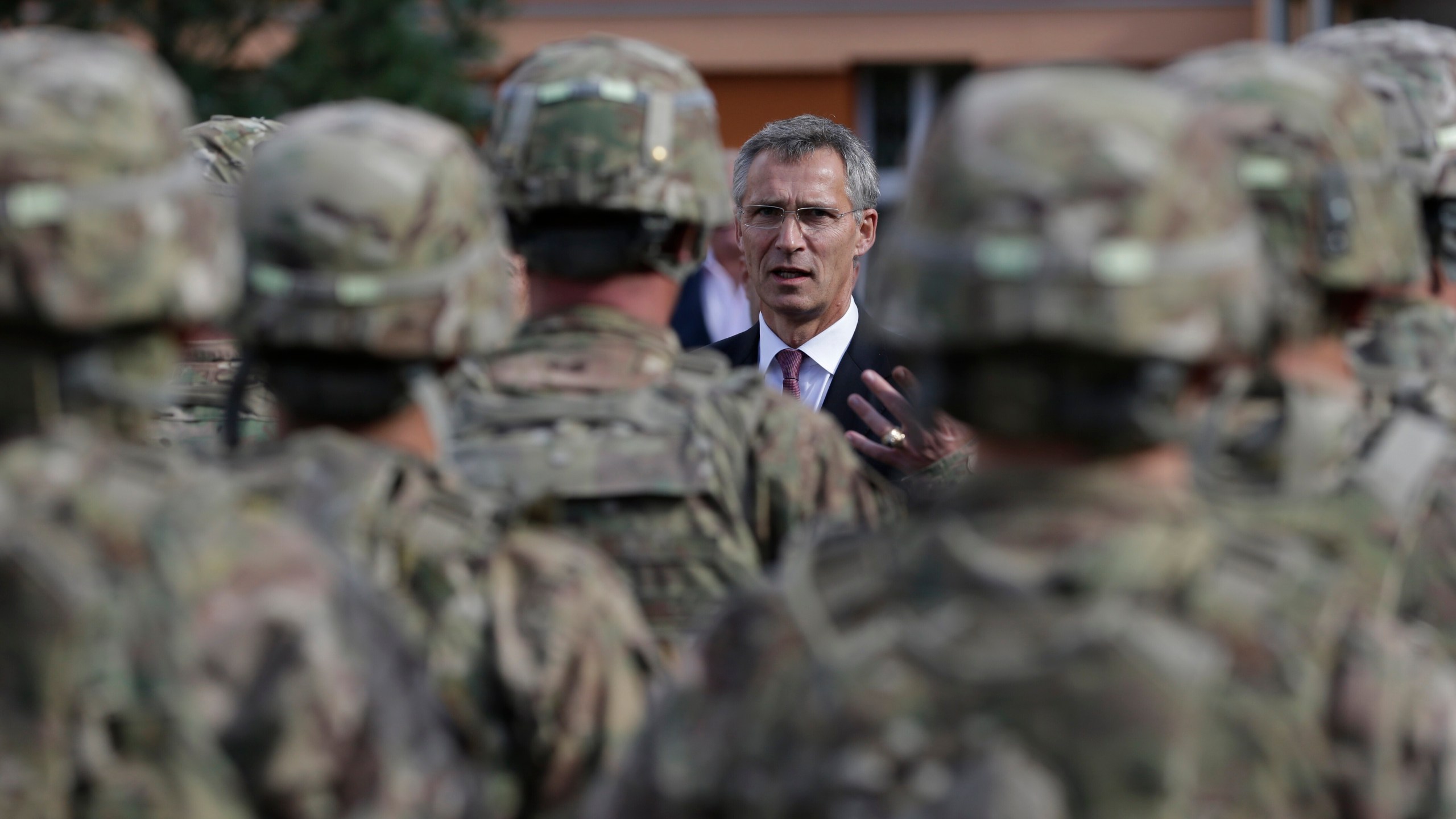 FILE - NATO Secretary General Jens Stoltenberg talks to US army soldiers while visiting Prague, Czech Republic, Wednesday, Sept. 9, 2015. On Wednesday April 26, 2023, the Czech government agreed to sign a defense military treaty with the United States. The treaty will set a legal framework for possible deployment of U.S. troops on Czech territory and their cooperation with the Czech armed forces. (AP Photo/Petr David Josek, File)