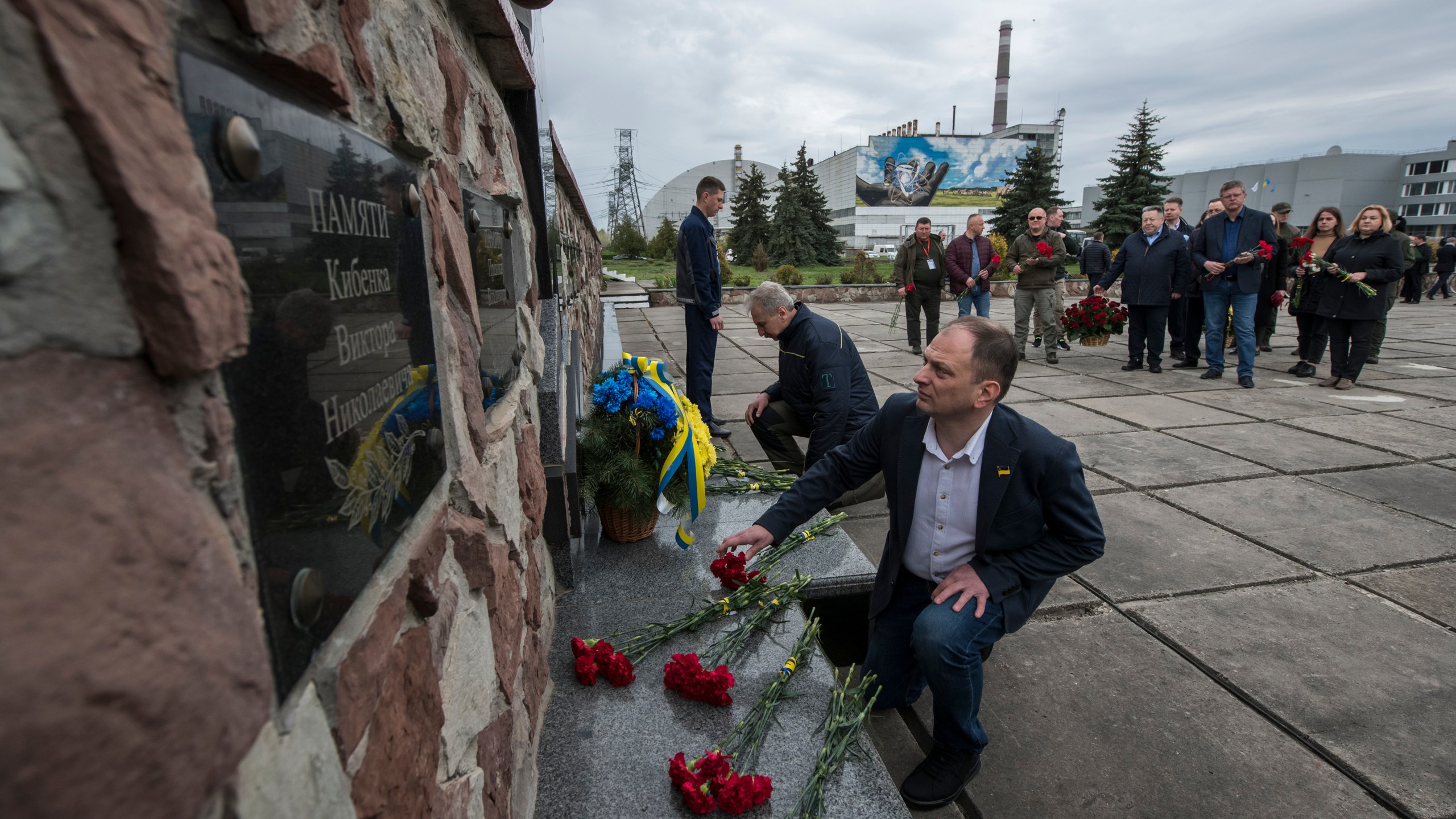 Chernobyl's nuclear power plant workers lay flowers at a monument to the victims of the Chernobyl tragedy during a memorial ceremony in Chernobyl, Ukraine, Wednesday, April 26, 2023. Ukrainian President Volodymyr Zelenskyy on Wednesday used the 37th anniversary of the world’s worst nuclear disaster to repeat his warnings about the potential threat of a new atomic catastrophe in Ukraine amid his country's war with Russia. (AP Photo/Wladyslaw Musiienko)