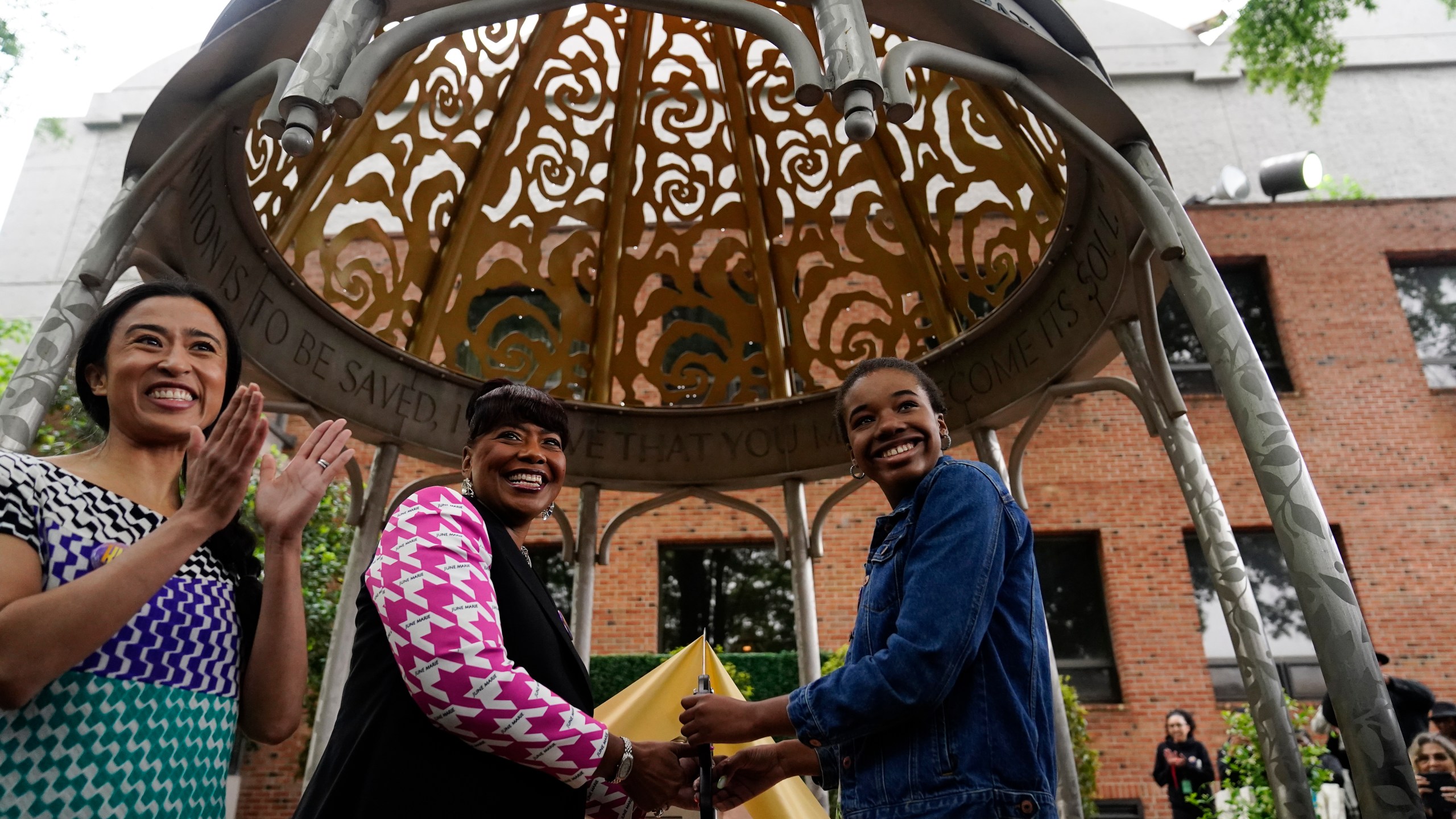 The Rev. Bernice King, center, daughter of the Rev. Martin Luther King Jr. and Coretta Scott King, granddaughter of Rev. Martin Luther King Jr., Yolanda Renee King, right, and artist Saya Woolfalk, left, attend during the dedication of the Coretta Scott King Peace and Meditation Garden and monument on Thursday, April 27, 2023, in Atlanta. (AP Photo/Brynn Anderson)