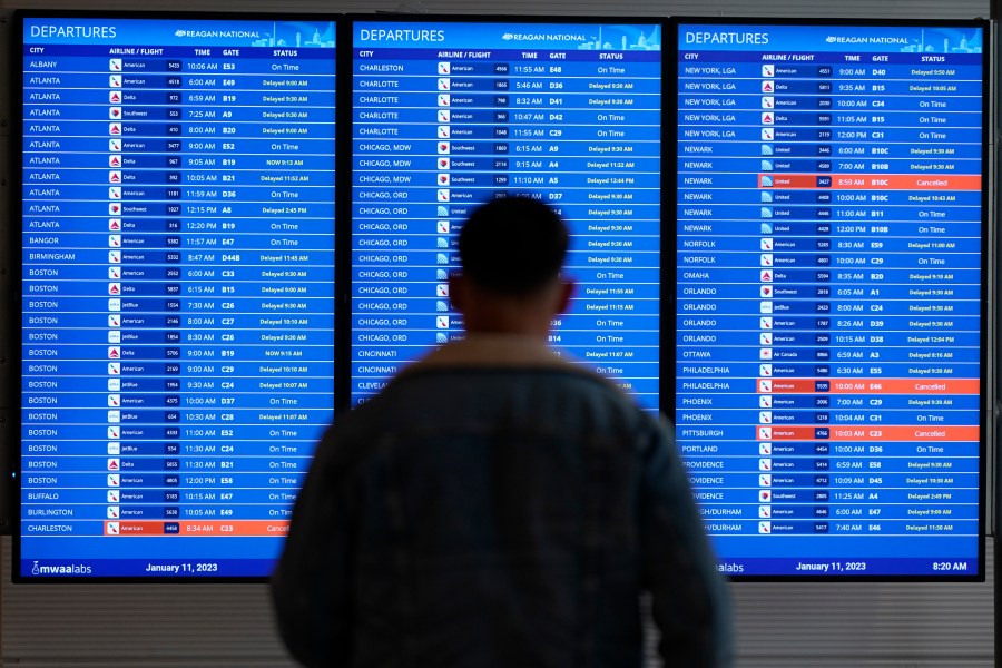 FILE - A traveler looks at a flight board with delays and cancellations at Ronald Reagan Washington National Airport in Arlington, Va., Wednesday, Jan. 11, 2023. Congressional investigators said in a report Friday, April 28, 2023, that an increase in flight cancellations as travel recovered from the pandemic was due mostly to factors that airlines controlled, including cancellations for maintenance issues or lack of a crew. (AP Photo/Patrick Semansky, File)