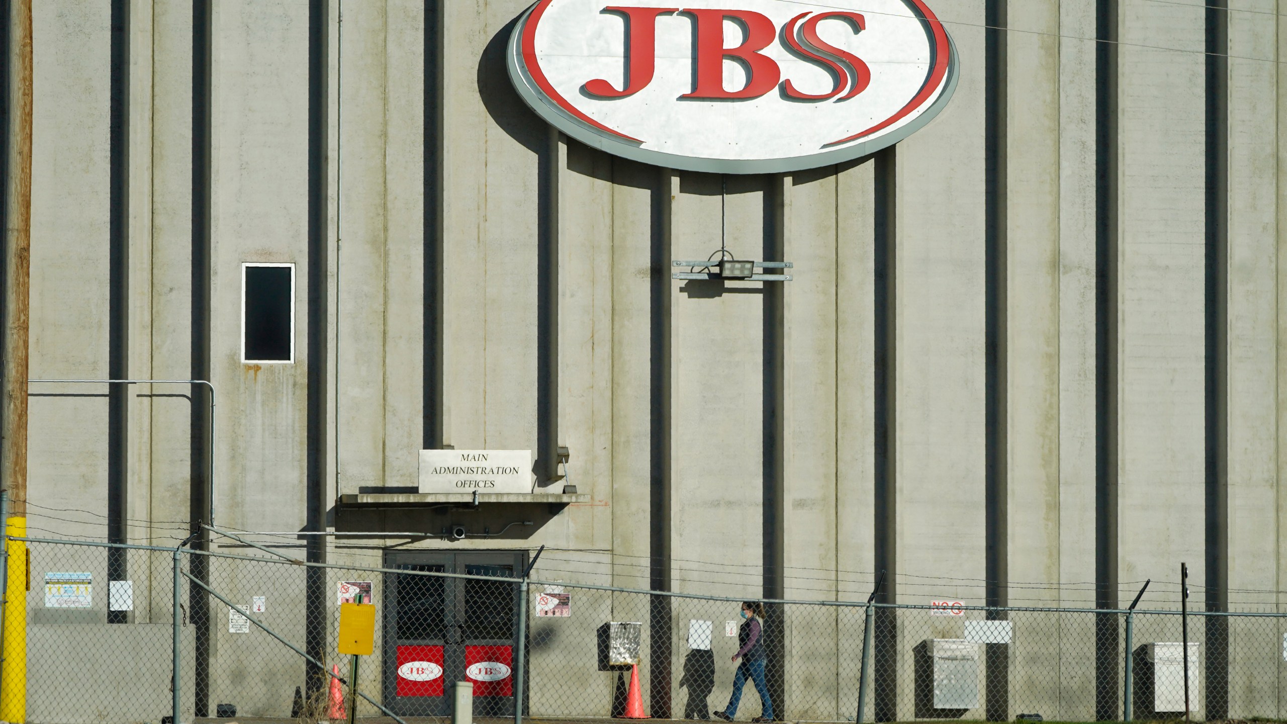 FILE - A worker heads into the JBS meatpacking plant in Greeley, Colo., Oct. 12, 2020. Packers Sanitation Services Inc. (PSSI), the slaughterhouse cleaning company that was found to be employing more than 100 children to help sanitize dangerous razor-sharp cutting equipment like bone saws, has continued to lose contracts with the major meat producers since the investigation became public in the fall of 2022. Cargill, Tyson Foods and JBS have all terminated contracts with PSSI at at least some of their plants. (AP Photo/David Zalubowski, File)