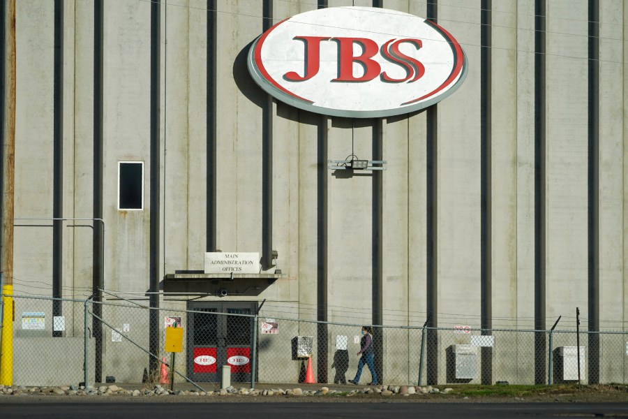 FILE - A worker heads into the JBS meatpacking plant in Greeley, Colo., Oct. 12, 2020. Packers Sanitation Services Inc. (PSSI), the slaughterhouse cleaning company that was found to be employing more than 100 children to help sanitize dangerous razor-sharp cutting equipment like bone saws, has continued to lose contracts with the major meat producers since the investigation became public in the fall of 2022. Cargill, Tyson Foods and JBS have all terminated contracts with PSSI at at least some of their plants. (AP Photo/David Zalubowski, File)