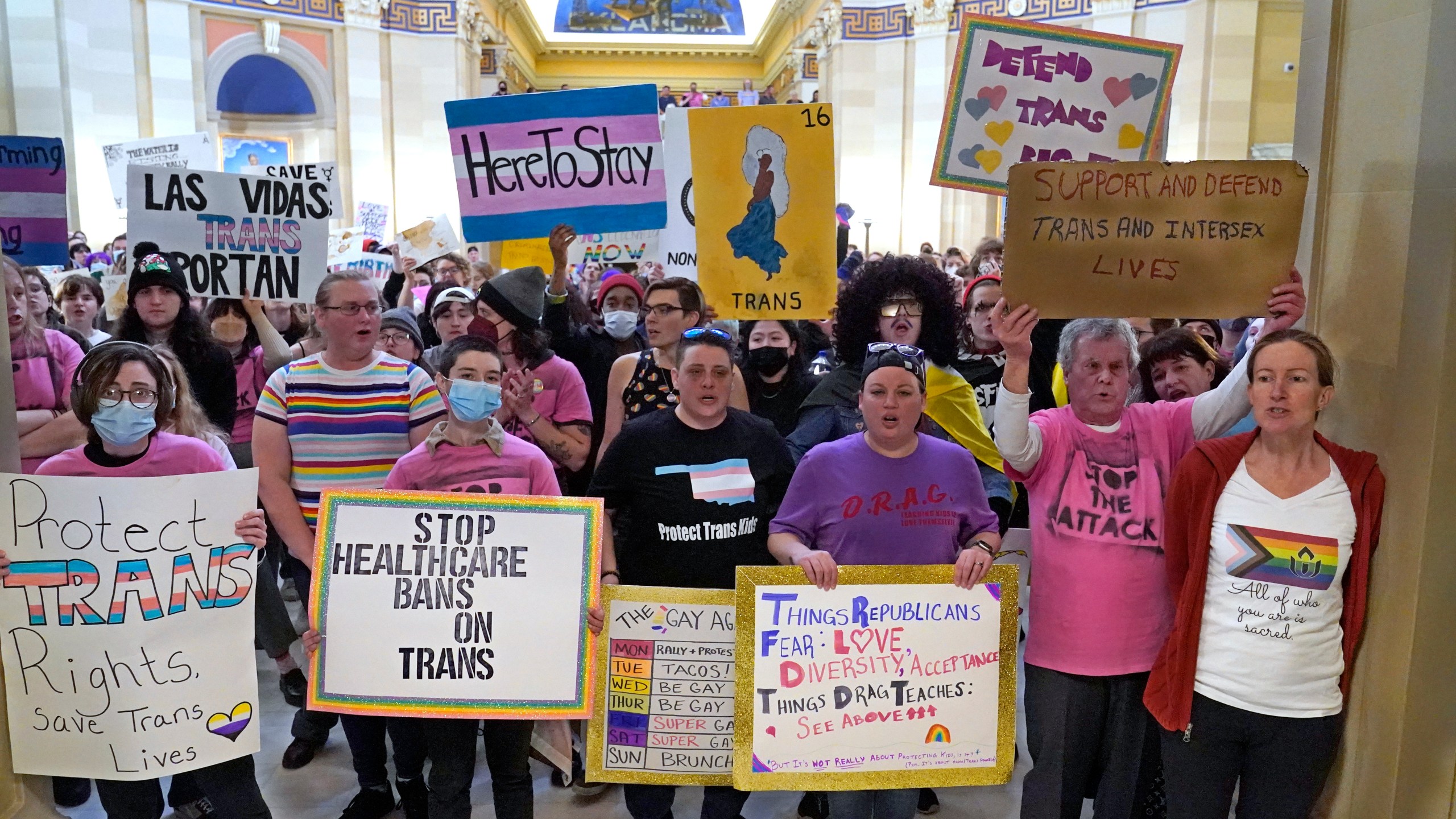 FILE - Trans-rights activists protest outside the House chamber at the Oklahoma Capitol before the State of the State address, Feb. 6, 2023, in Oklahoma City. On Monday, May 1, Oklahoma became the latest state to ban gender-affirming medical care for minors as Republican Gov. Kevin Stitt signed a bill that makes it a felony for health care workers to provide children with treatments that can include puberty-blocking drugs and hormones. (AP Photo/Sue Ogrocki, File)