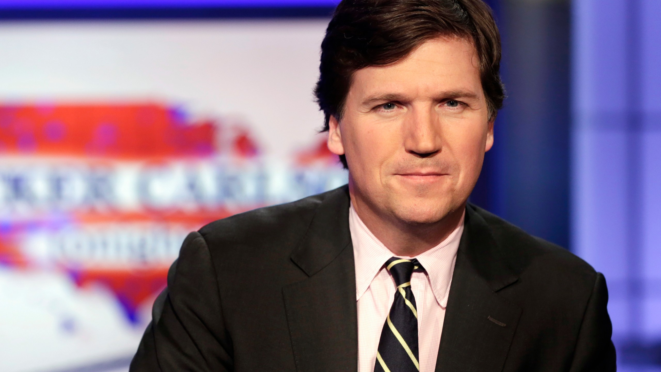 FILE - Tucker Carlson, host of "Tucker Carlson Tonight," poses for photos in a Fox News Channel studio on March 2, 2017, in New York. A racist text message from Tucker Carlson is what helped drive the commentator's ouster from Fox News, The New York Times reports. The Times says that in a text uncovered as part of a recent defamation lawsuit, the former Fox host lamented how supporters of former President Donald Trump ganged up to beat a protester. “It's not how white men fight,” Carlson wrote. (AP Photo/Richard Drew, File)