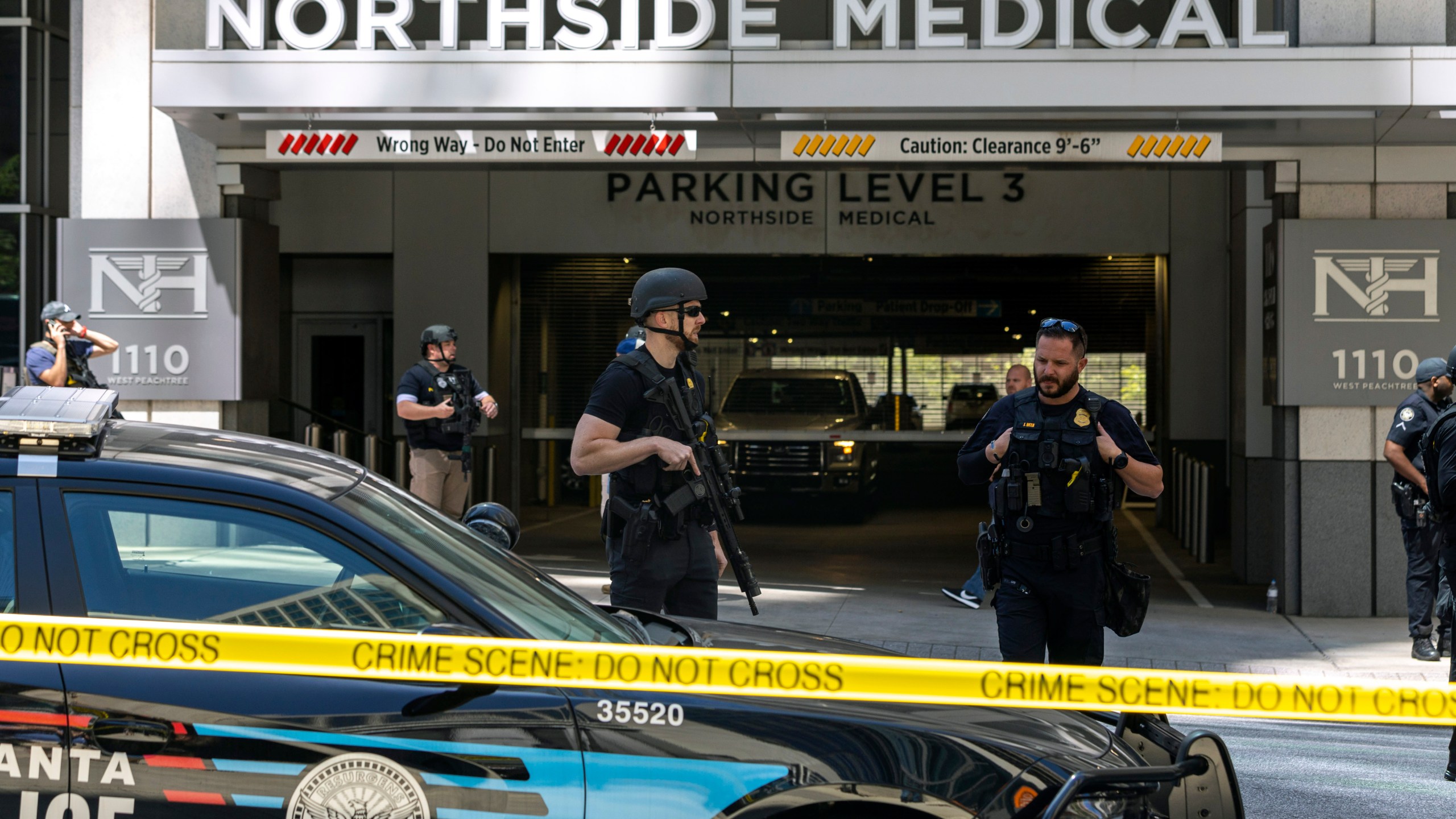 Law enforcement officers stand Northside Hospital Midtown medical office building, where five people were shot, Wednesday, May 3, 2023, in Atlanta. Authorities swarmed the city’s bustling midtown neighborhood in search of the 24-year-old suspect. (Arvin Temkar/Atlanta Journal-Constitution via AP)