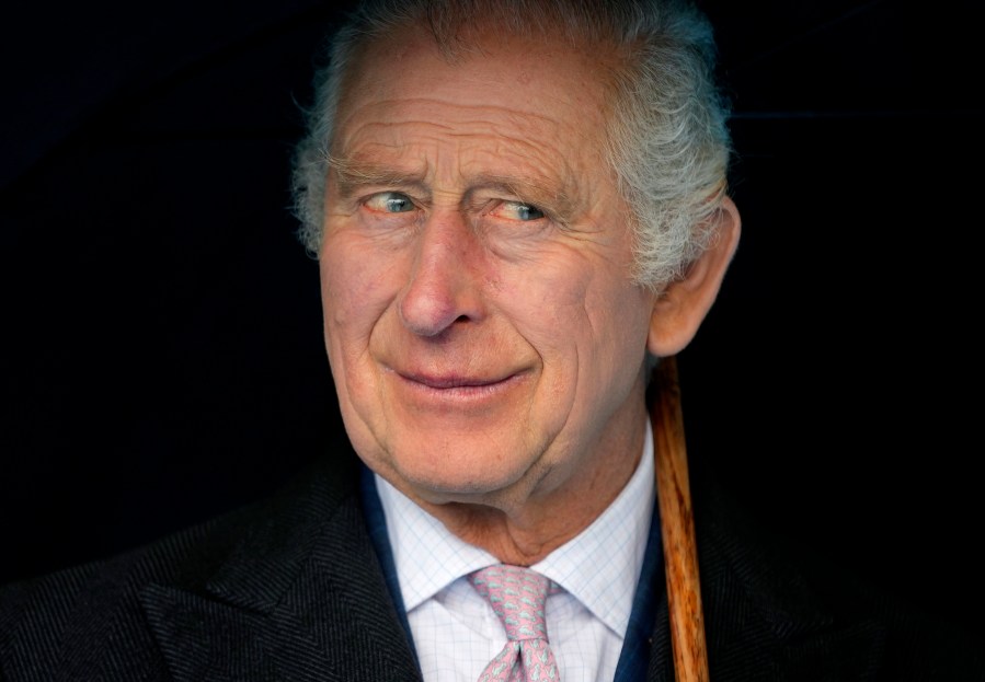 FILE - Britain's King Charles III smiles during a boat trip, in Hamburg, Germany, Friday, March 31, 2023. King Charles III arrived Wednesday for a three-day official visit to Germany. Britain’s royal family turns the page on a new chapter with the coronation of King Charles III. Charles ascended the throne when his mother, Queen Elizabeth II, died last year. But the coronation Saturday is a religious ceremony that provides a more formal confirmation of his role as head of state and titular head of the Church of England. (AP Photo/Matthias Schrader, Pool, File)