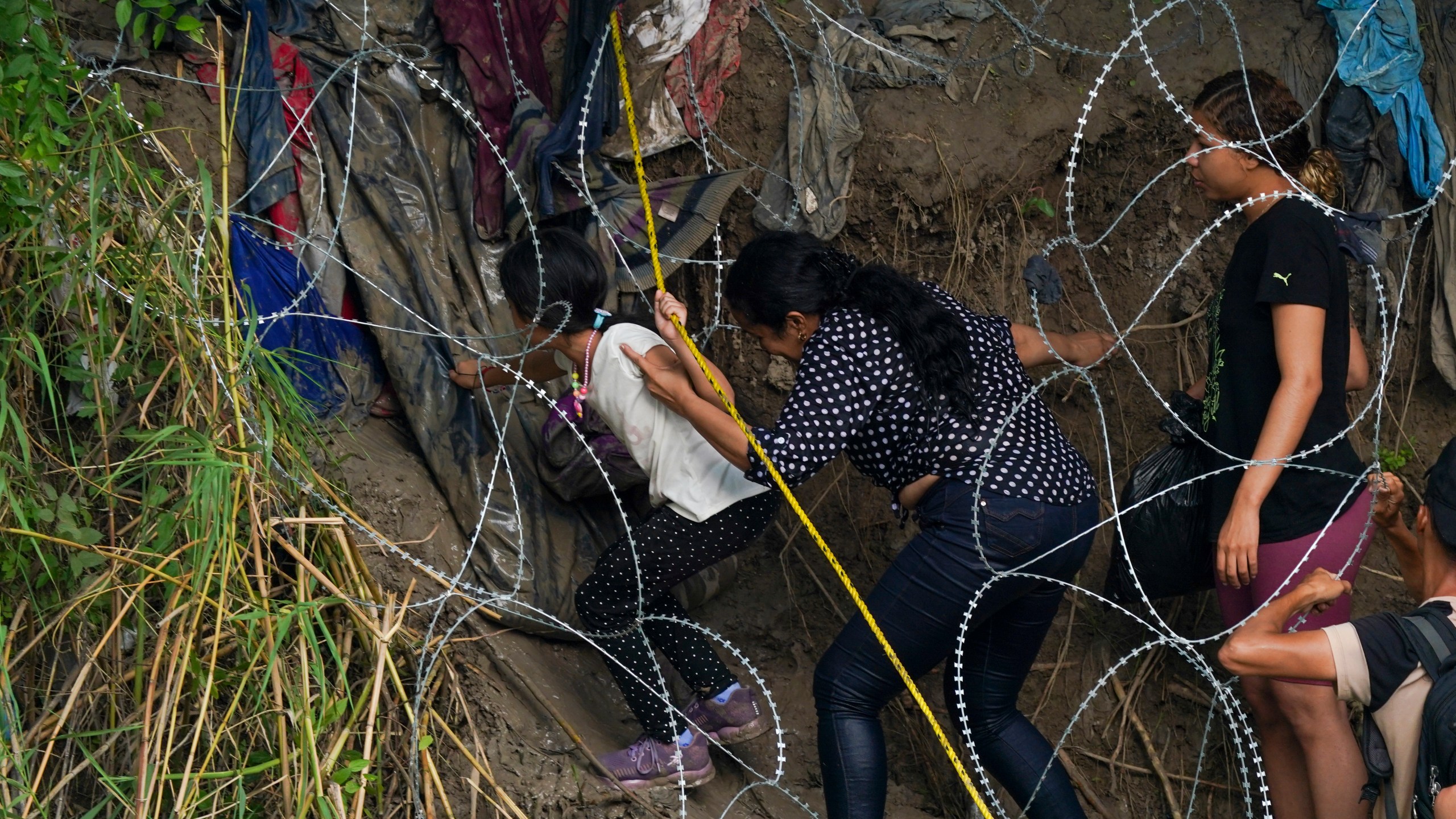 Migrants walk through a barbed-wire barrier into the United States after crossing the Rio Bravo from Matamoros, Mexico, Tuesday, May 9, 2023. The U.S. is preparing for the Thursday, May 11th end of the Title 42 policy, linked to the coronavirus pandemic that allowed it to quickly expel many migrants seeking asylum. (AP Photo/Fernando Llano)