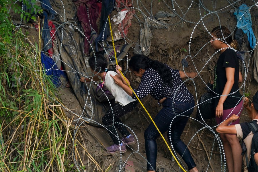 Migrants walk through a barbed-wire barrier into the United States after crossing the Rio Bravo from Matamoros, Mexico, Tuesday, May 9, 2023. The U.S. is preparing for the Thursday, May 11th end of the Title 42 policy, linked to the coronavirus pandemic that allowed it to quickly expel many migrants seeking asylum. (AP Photo/Fernando Llano)