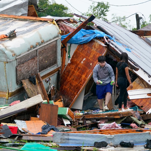 People salvage items from a home after a tornado hit Saturday, May 13, 2023, in the unincorporated community of Laguna Heights, Texas near South Padre Island. Authorities say one person was killed when a tornado struck the southernmost tip of Texas on the Gulf coast. (AP Photo/Julio Cortez)