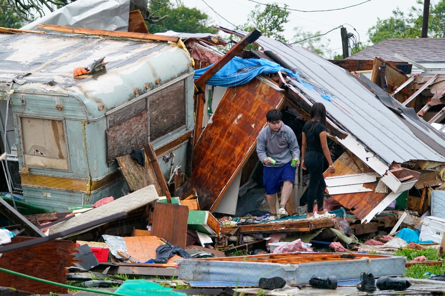 People salvage items from a home after a tornado hit Saturday, May 13, 2023, in the unincorporated community of Laguna Heights, Texas near South Padre Island. Authorities say one person was killed when a tornado struck the southernmost tip of Texas on the Gulf coast. (AP Photo/Julio Cortez)