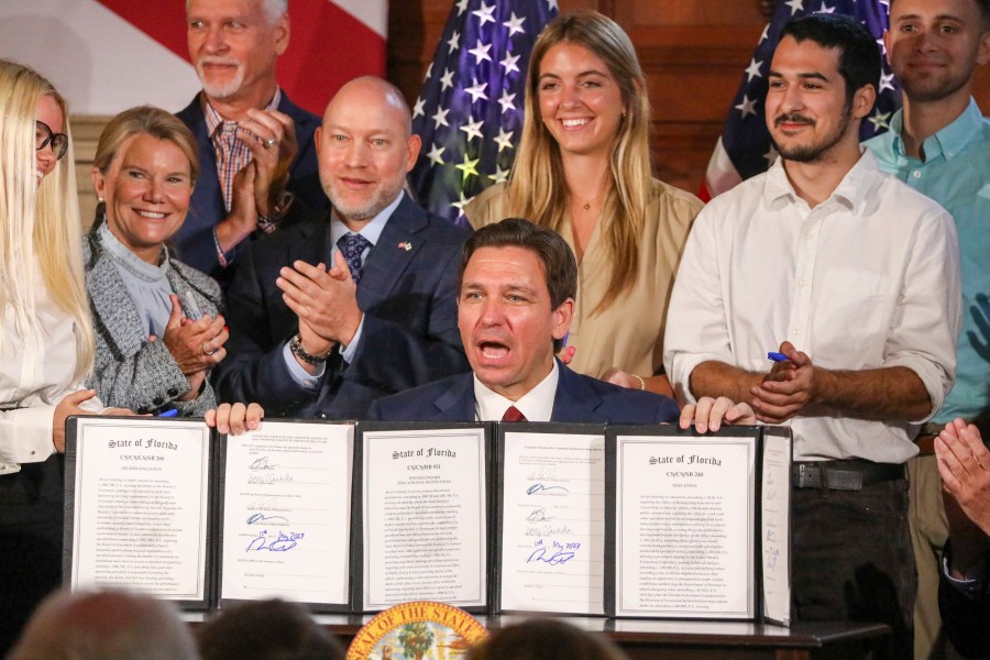 Florida Gov. Ron DeSantis signs legislation on Monday, May 15, 2023, banning state funding for diversity, equity, and inclusion programs at Florida's public universities, at New College of Florida in Sarasota, Fla. (Douglas R. Clifford/Tampa Bay Times via AP)